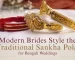 Gold-plated traditional sankha pola bangles featuring an intricate floral motif centerpiece on a white fabric background for a modern Bengali bride.